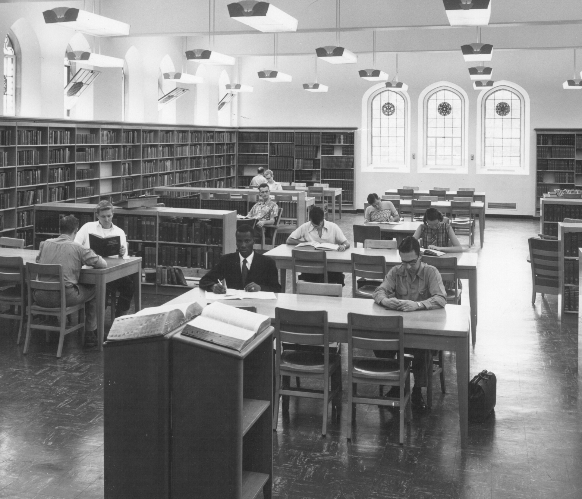 Black and white photograph of students working in the old library