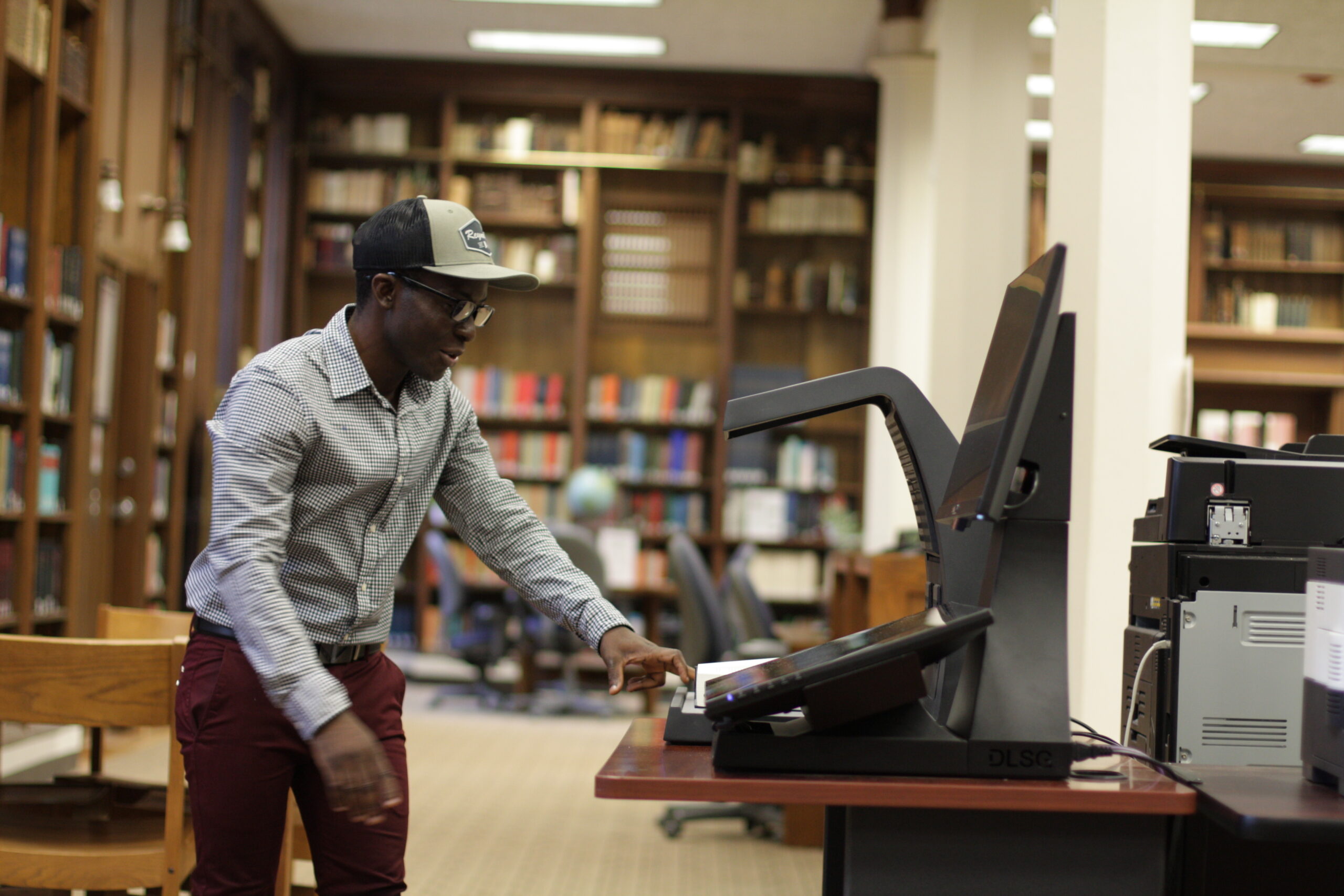 Photo of student worker using the KIC Scanner in Styberg Library