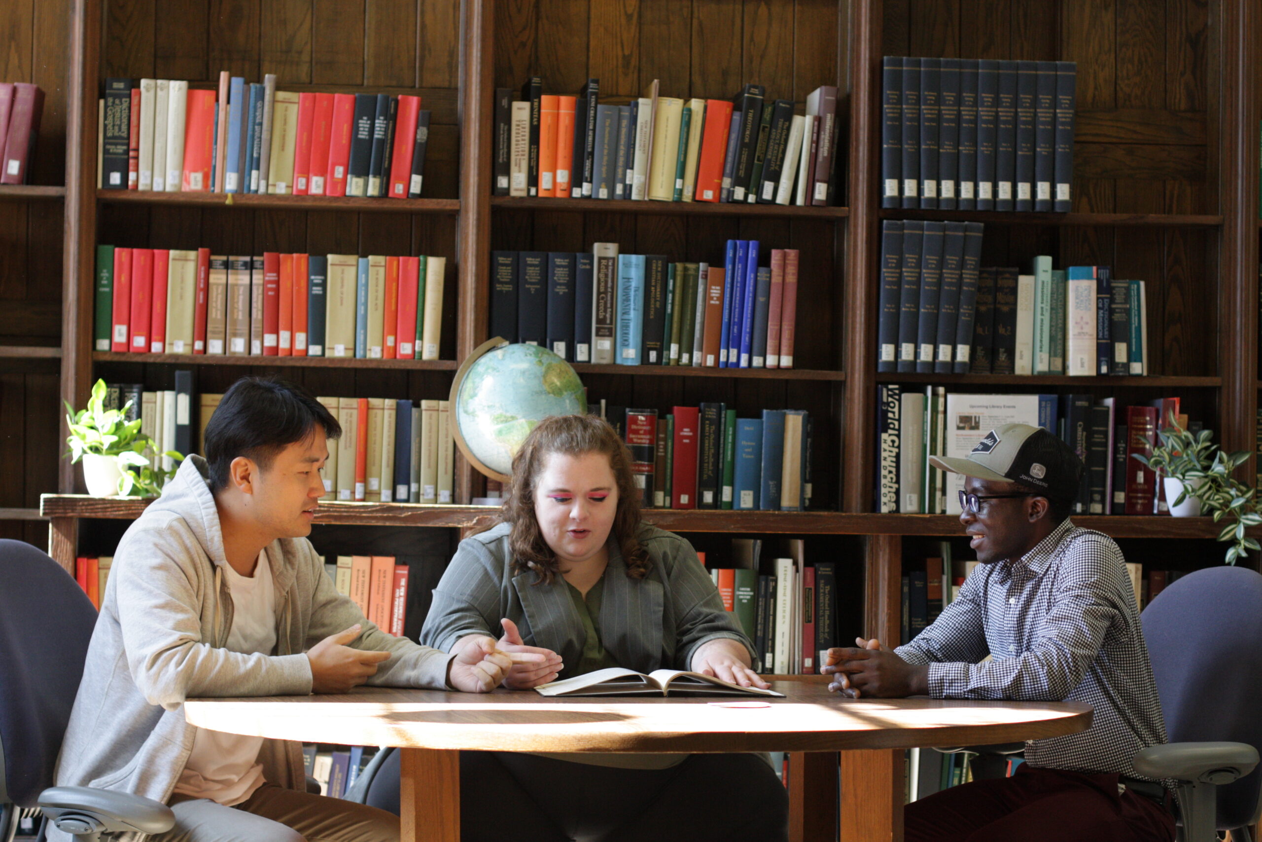 Photo of three students working together in Styberg Library